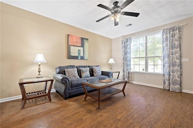 Living area with dark wood finished floors, basebo