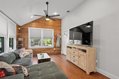 Living room featuring visible vents, wooden walls