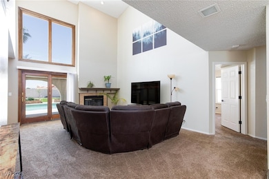 Carpeted living area with a tiled fireplace, a hig