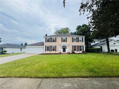 Colonial house featuring a garage and a front yard
