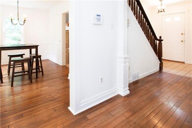 entryway, hallway leading to living room, den and 