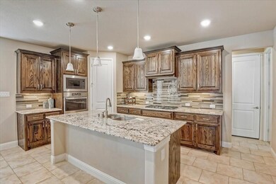 Kitchen featuring backsplash, hanging light fixtures, stainless steel appliances, light tile patterned floors, and recessed lighting
