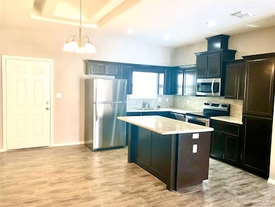 Kitchen with stainless steel appliances, backsplash, visible vents, a sink, and a chandelier