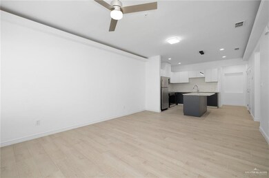 Unfurnished living room featuring sink, light hardwood / wood-style flooring, and ceiling fan