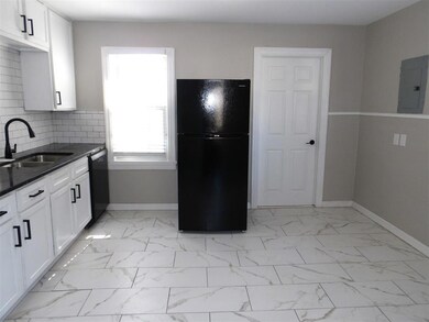 Kitchen with backsplash, white cabinets, sink, bla