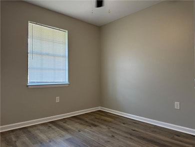 Spare room with dark wood-type flooring and ceiling fan
