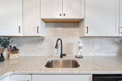 Kitchen featuring decorative backsplash, light sto