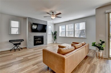 Living area featuring a fireplace, ceiling fan, ba
