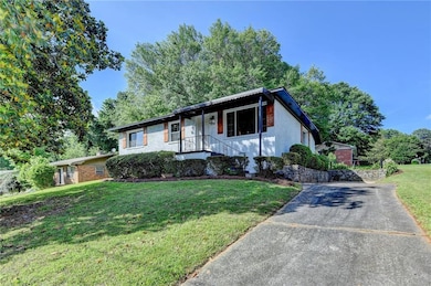 View of front facade featuring a front yard, concrete driveway, and brick siding