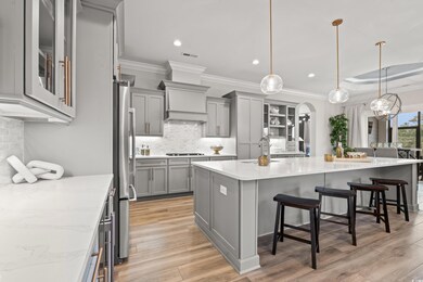 Kitchen with gray cabinetry, hanging light fixture