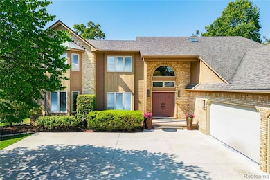 View of front of home with brick siding, a shingled roof, concrete driveway, and an attached garage