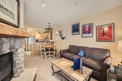 Carpeted living room with baseboard heating, rail