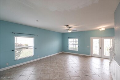 Spare room with ceiling fan, french doors, baseboa