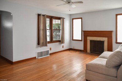 The living room has hardwood flooring and a firepl