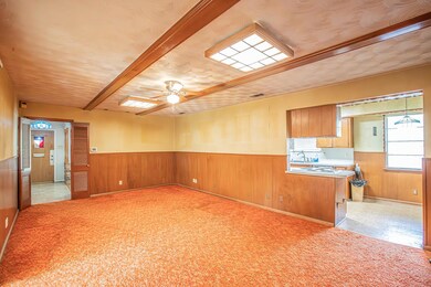 Empty room featuring light carpet, wainscoting, vi