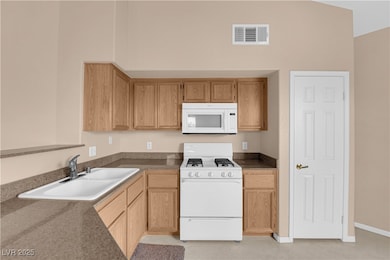 Kitchen featuring dark countertops, visible vents,