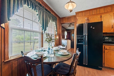 Dining room with wood walls, a ceiling fan, washin