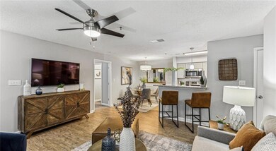 Living room with a textured ceiling, ceiling fan, 