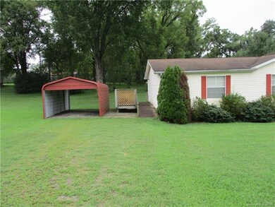Single carport, side deck, gravel under grass