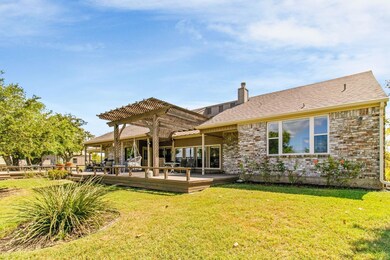 Back of house with a pergola, a chimney, a yard, a