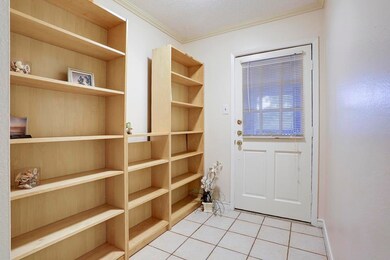 Home boasts wall of shelving at entry!