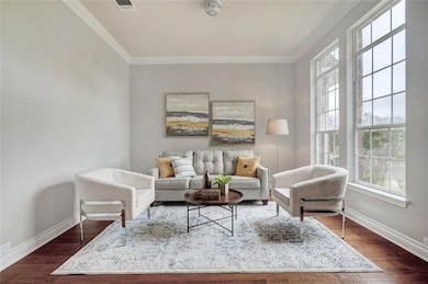 Living room featuring crown molding and dark wood