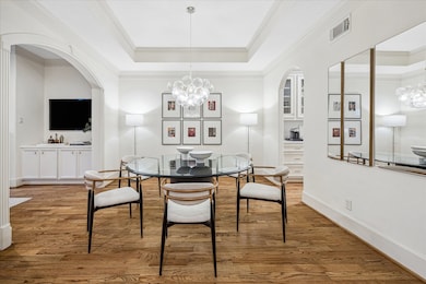 Spectacular glass pendant chandelier anchors the dining room in between the kitchen and living room. Modern, open concept living.