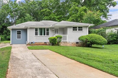 View of front facade featuring a front yard, brick siding, and crawl space