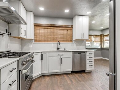 Kitchen with a sink, wall chimney range hood, appl
