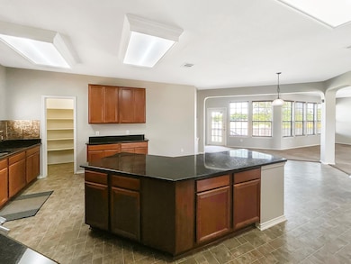 Kitchen with a kitchen island, arched walkways, o