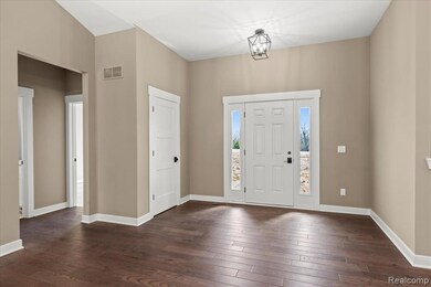 Foyer with dark wood-type flooring and a chandelier