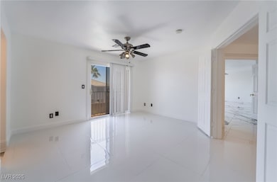 Empty room with baseboards, ceiling fan, and tile