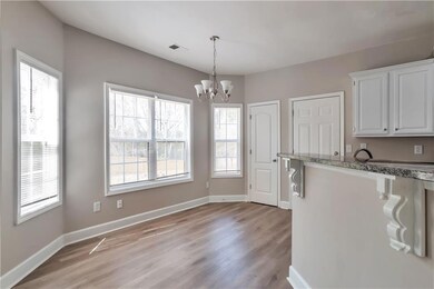 Kitchen featuring white cabinets, baseboards, visi