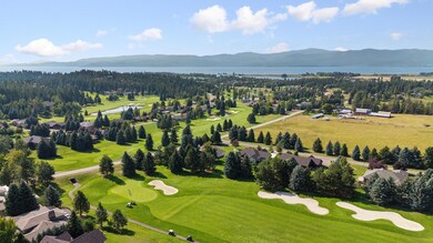 Aerial of golf course, home & Flathead Lake in distance