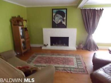 Living room has pine floors and a fireplace. Very charming