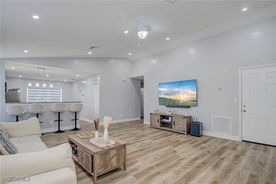Living room featuring lofted ceiling, light wood f