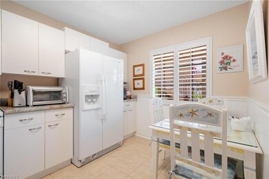 Kitchen with light tile patterned floors, white fr