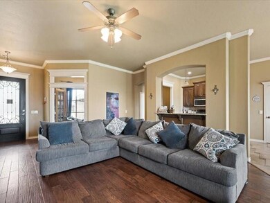 Living room featuring crown molding, dark hardwood