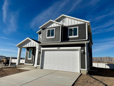 View of front of property with board and batten siding, a garage, and driveway