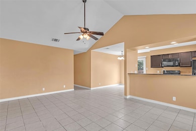 Unfurnished living room featuring high vaulted ce
