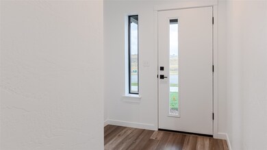 Entrance foyer with dark wood finished floors and a textured wall