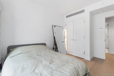 Bedroom with light wood-type flooring and a closet