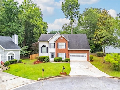 View of front of house with brick siding, driveway, and a garage
