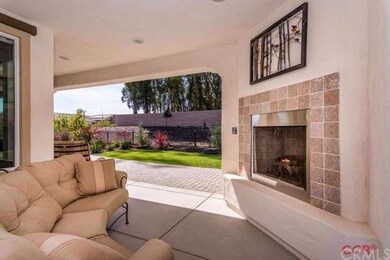 Covered patio living space with corner fireplace.