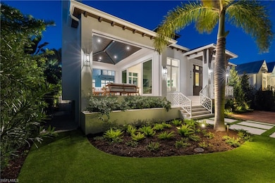 Covered lanai with gas grill, fireplace, refrigerator, screens, and shades.