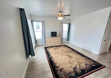 Unfurnished bedroom with light wood-type flooring, a ceiling fan, and a textured ceiling