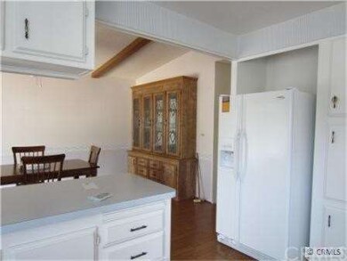 Kitchen showing refrigerator and adjacent dining a