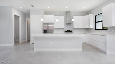 Kitchen featuring wall chimney range hood, stainle