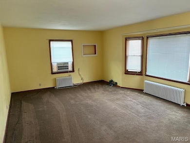 Carpeted spare room with radiator, healthy amount of natural light, and cooling unit