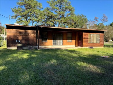 Back of house featuring a yard and central air con